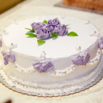 Weisse Hochzeitstorte mit lila Rosen